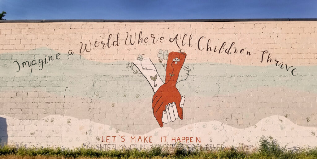 Mural of diverse hands with text "World Where all Children Thrive"