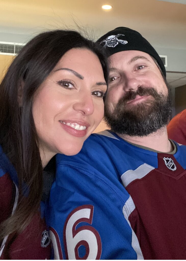 Jennifer and James smiling wearing team jerseys.